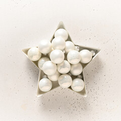 Christmas star with white balls on white. Creative greeting card. Top view. Alternative Creative Xmas.