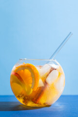 Sangria punch cocktail with orange, apple and cinnamon on blue background. Fruit drink for party