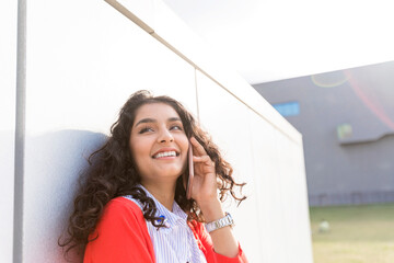 Close up happy young woman talking with cellphone outside in city