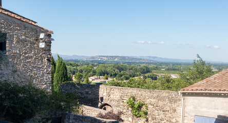 Obraz premium murs anciens dans un village en ruine du lubéron en France et le panorama sur la plaine de la vallée du rhône, sa végétation méditerranéenne et ses collines un jour ensoleillé 