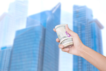 Plan save money 2021 concept. croped hand woman holding 
banknote on blur image of building. 