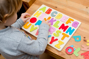 Baby early learning. Wooden letters of the alphabet. Children reading puzzle. Kids educational...