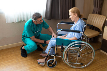 Orthopedic doctor examining senior woman knee in hospital. Doctor checking elderly woman patients knee