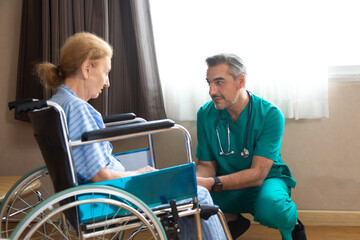 Orthopedic doctor examining senior woman knee in hospital. Doctor checking elderly woman patients knee