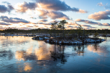 Swamp lake with islands in sunny winter day in sunrise