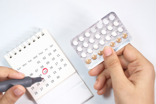 birth control pills , calendar and notepad on table 