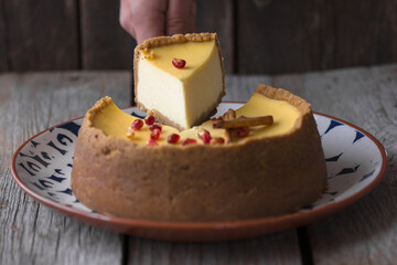 Close-up shot of a piece of cheesecake on a plate next to a whole cheesecake