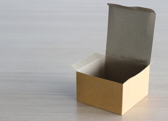 Open paper box on wooden table background