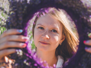 Woman hands with colorful manicure holding lavender wreath
