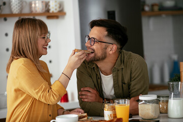 Young couple making sandwich at home. Loving couple enjoying in the kitchen..