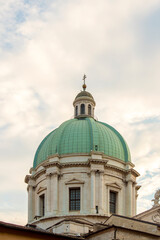 Panoramic view of Paolo VI square in Brescia, Lombardy Region - Italy. Sunset scene with clear sky, a stone church tower on the right and bricks houses around the square.