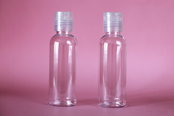 Isolated spa cosmetic products, transparent tube on a pink background. Plastic bottle for detergent cleaning agent.