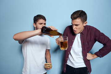Two cheerful drunk friends drinking beer lifestyle emotions on a blue background