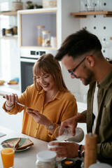 Young couple making sandwich at home. Loving couple enjoying in the kitchen..