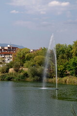 Fototapeta premium Fragment of artificial pond and fountain with beauty drops in residential district Drujba, Sofia, Bulgaria 