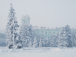 City after snowfall. Trees and buildings covered with snow.