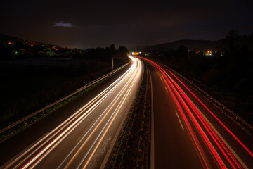 Fototapeta na wymiar Red light trails of a car and truck on a motorway