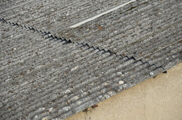 An old asbestos roof made of corrugated tiles is a hazardous environmental waste that must end up...