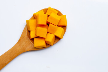 Cut and slices butternut squash on wooden spoon on white