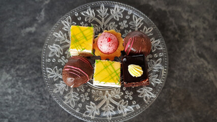 Small cakes on a plate different on a gray background