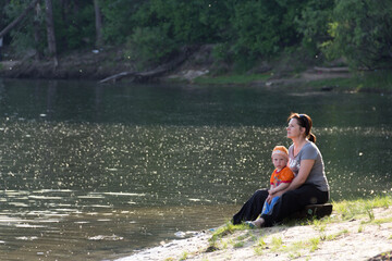mother with little son by the water on the lake
