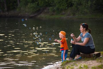mother with little son by the water on the lake