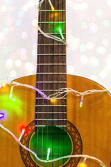 Acoustic guitar wrapped by colorful garland. christmas and new year music gift