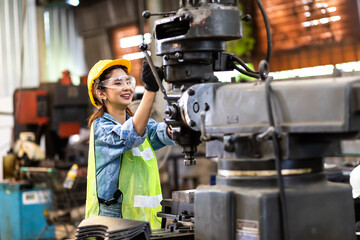 Woman worker wearing safety goggles control lathe machine to drill components. Metal lathe...