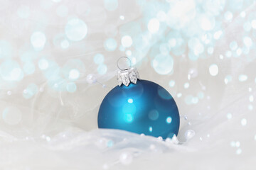 blue christmas ball with silk and pearls and bokeh