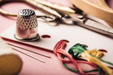 Embroidery set fot cross stitching. White fabric, thimble, embroidery hoop, colorful threads,...