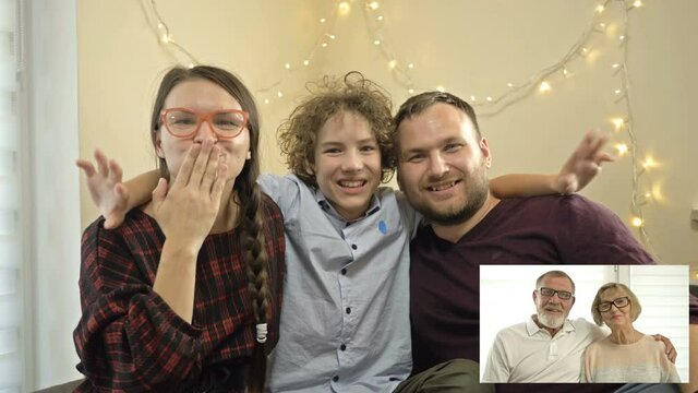 Young family congratulates their elderly parents who live far away, Merry Christmas. Modern technologies. Family video call concept.