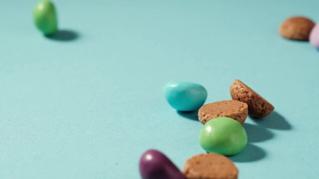 Scattered traditional dutch cookies kruidnoten gingersnap over blue background. St Nicholas day Sinterklaas in December, children holiday in Netherlands and Belgium. Full HD video, 100 fps slow motion