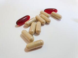 Brown and red oval pills on a white background Iron and curcumin supplements
