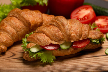 Close up vegan croissant, healthy vegetarian breakfast. Vegan croissants sandwiches on wooden board, healthy vegetarian food concept