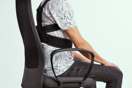 man wearing a posture corrector while sitting