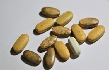 Rotten or expired or out of date brown pills isolated on white background