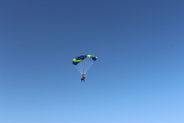 Person falling from the sky by parachute