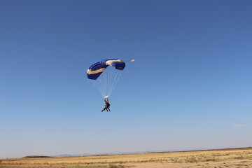 Persona aterrizando en tierra en paracaidas
