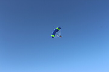 Obraz na płótnie Canvas Person falling from the sky by parachute