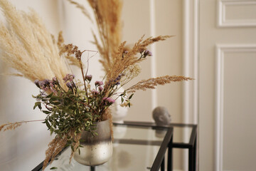 Cute little dried flowers in small glass vase in the living room. © brillianata