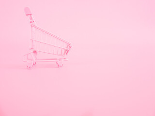 shopping and payment concept from small trolley on pink pastel color background.