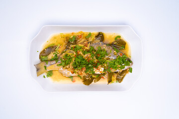 The top angle of Ikan Siakap (Scientific name: Lates calcarifer) a typical Asian cuisine food. Isolated on white background