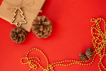 on a red table in a Christmas tree cones and a gift Christmas background