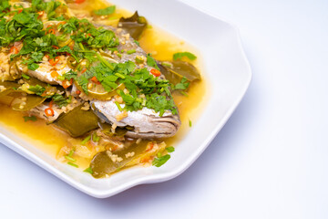 Close-up shot of Ikan Siakap (Scientific name: Lates calcarifer) a typical Asian cuisine food. Isolated on white background