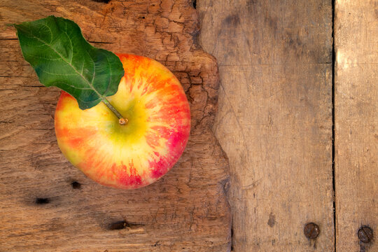 apple with leaf on antique cutting baord