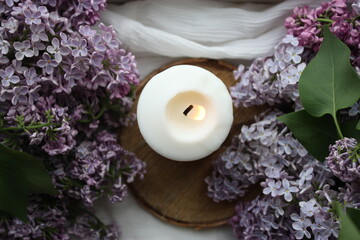 Obraz na płótnie Canvas Lilacs and a candle in a home interior