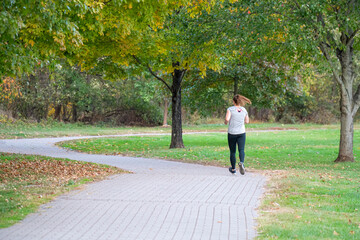 Fototapeta premium young woman jogging on a brick path