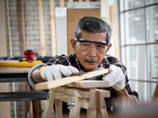 Portrait of a senior carpenter looking at the camera in his work environment.
