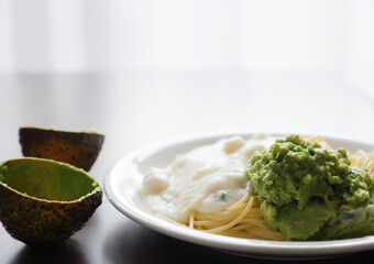 スパゲティにのせたマッシュしたアボカド
