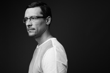 Portrait of handsome man with beard stubble against gray background
